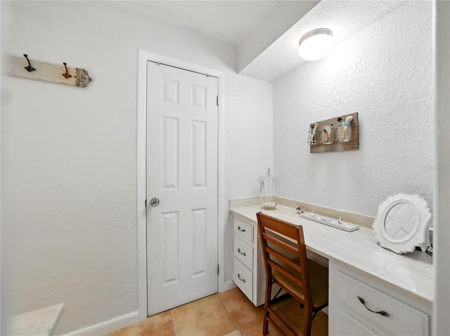 bathroom featuring a textured wall and tile patterned flooring