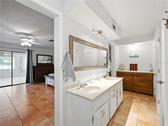full bath featuring double vanity, tile patterned floors, a ceiling fan, and a sink