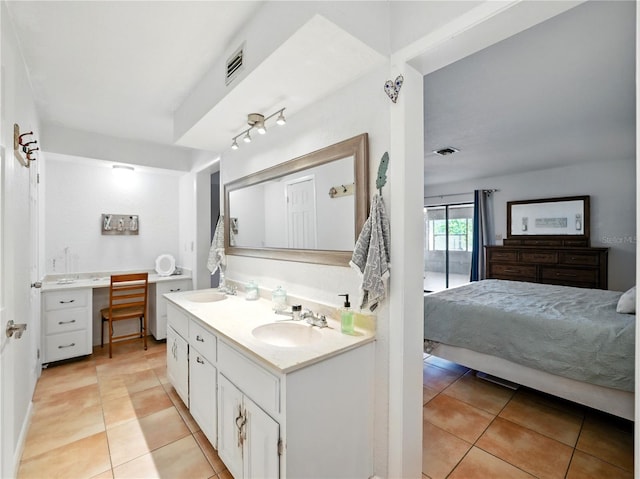 ensuite bathroom with ensuite bath, tile patterned floors, and a sink
