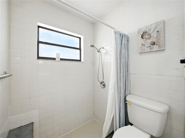 full bath with toilet, tile walls, and tiled shower