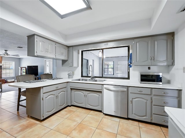 kitchen with plenty of natural light, gray cabinetry, a sink, and appliances with stainless steel finishes