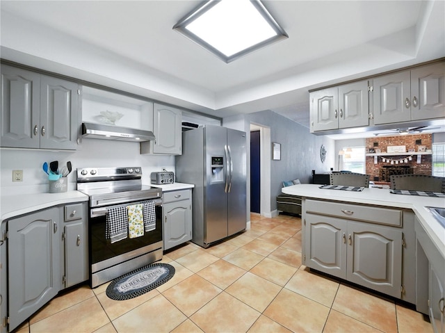 kitchen featuring under cabinet range hood, gray cabinetry, stainless steel appliances, and light countertops