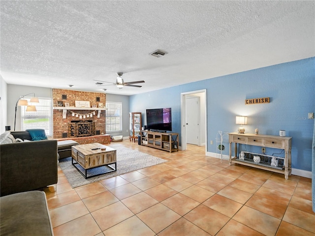 living room featuring a ceiling fan, visible vents, light tile patterned floors, and a healthy amount of sunlight