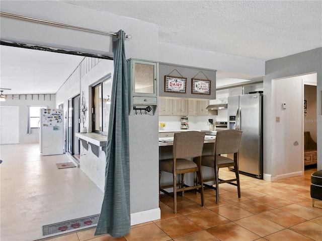 dining room with a textured ceiling and light tile patterned flooring