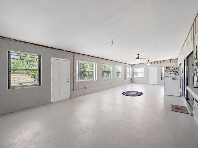 interior space with a ceiling fan and freestanding refrigerator