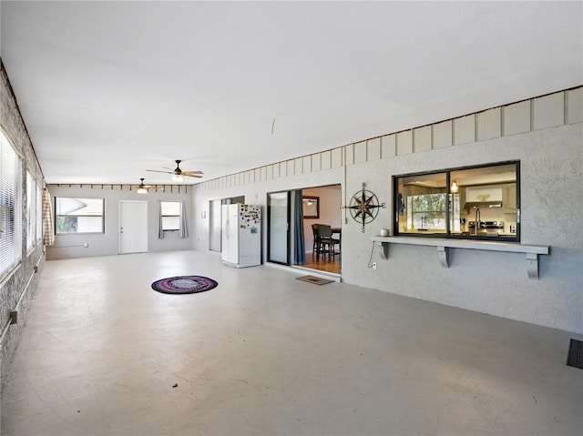 interior space featuring concrete flooring and ceiling fan