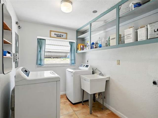 laundry area featuring baseboards, independent washer and dryer, laundry area, and light tile patterned floors