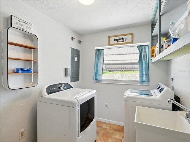 laundry area featuring washing machine and clothes dryer, a sink, electric panel, baseboards, and laundry area