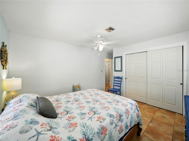 bedroom featuring a closet, visible vents, ceiling fan, and light tile patterned floors