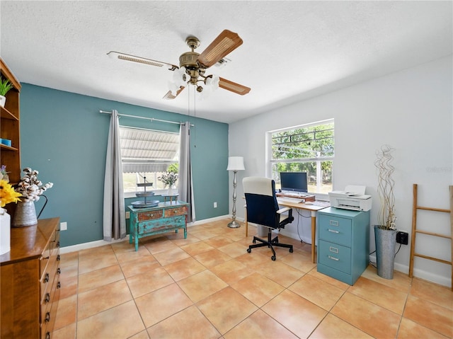office featuring baseboards, a ceiling fan, a textured ceiling, and light tile patterned floors