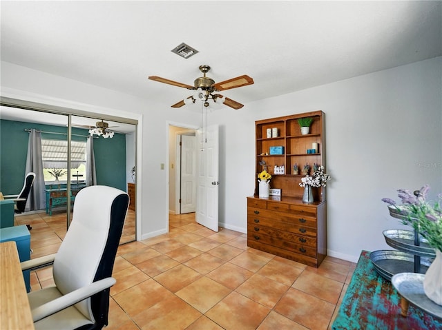 home office with baseboards, a ceiling fan, visible vents, and light tile patterned floors