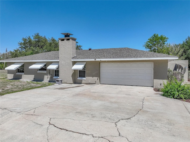 view of front of home with a garage, driveway, a chimney, and stucco siding