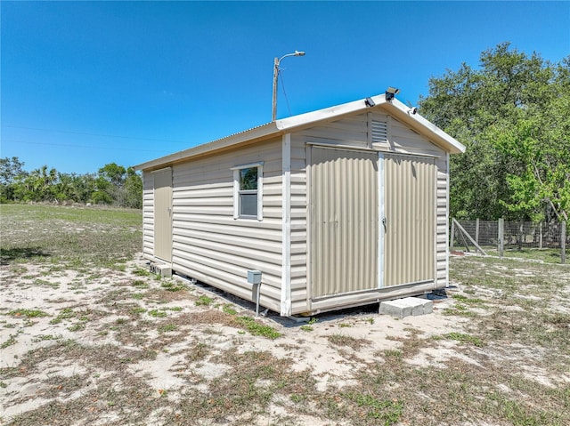 view of shed featuring fence