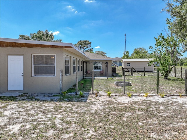 rear view of property with fence and stucco siding