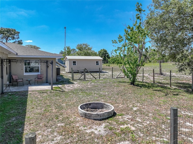 view of yard with a fenced backyard, an outdoor fire pit, and a patio