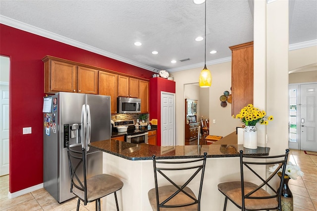 177 Costa Loop, Auburndale, FL 33823 - kitchen with stainless steel appliances, light tile patterned flooring, ornamental molding, a peninsula, and recessed lighting