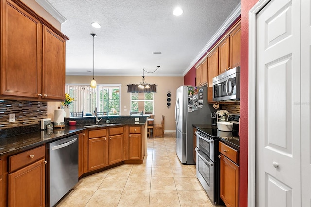 177 Costa Loop, Auburndale, FL 33823 - kitchen featuring stainless steel appliances, a sink, brown cabinets, crown molding, and tasteful backsplash