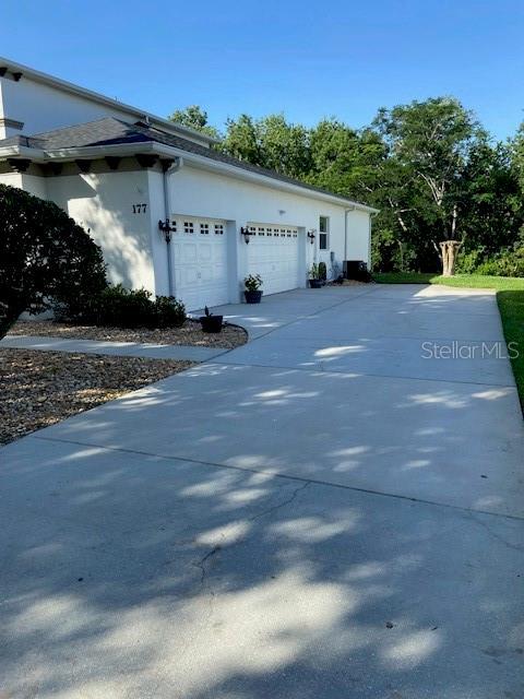 177 Costa Loop, Auburndale, FL 33823 - view of property exterior featuring stucco siding, concrete driveway, and an attached garage