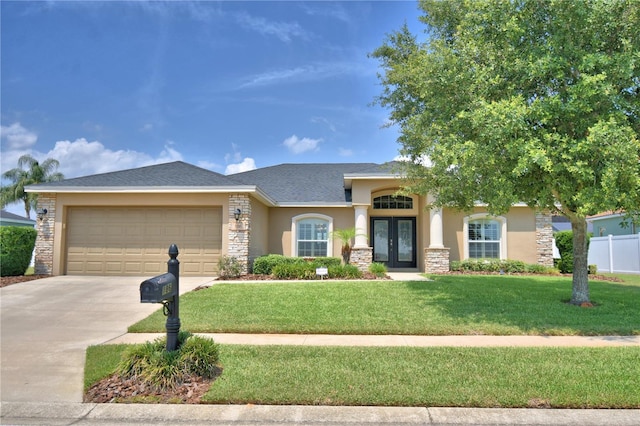 186 Viola Dr, Auburndale, FL 33823 - view of front of property featuring french doors, stucco siding, a garage, concrete driveway, and stone siding