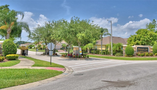 186 Viola Dr, Auburndale, FL 33823 - view of asphalt street featuring traffic signs, sidewalks, street lights, curbs, and a gate