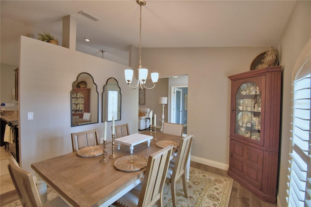 186 Viola Dr, Auburndale, FL 33823 - dining room with vaulted ceiling, a chandelier, light wood finished floors, and baseboards