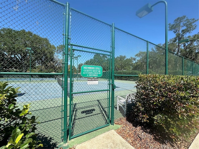 view of sport court featuring fence and a gate