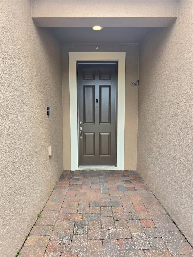 property entrance with stucco siding