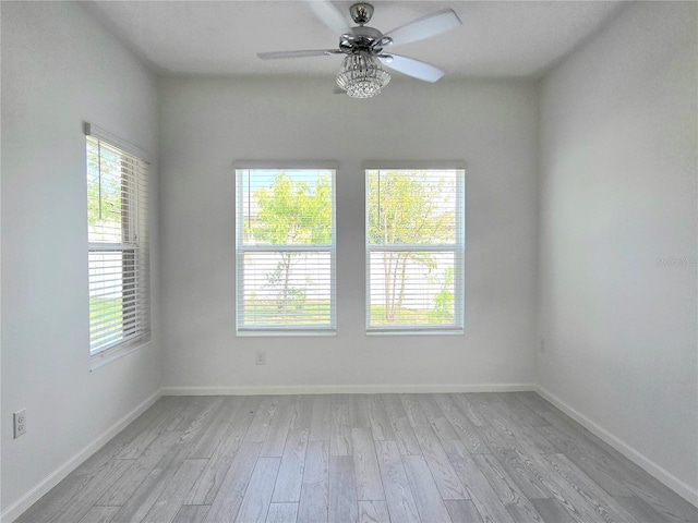 empty room featuring baseboards, ceiling fan, and light wood finished floors