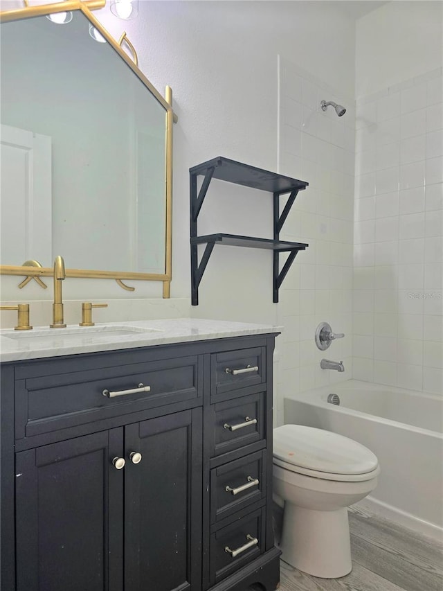 bathroom featuring wood finished floors, toilet, shower / tub combination, and vanity