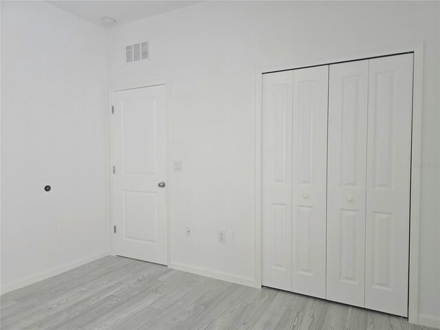 625 Disa Dr, Davenport, FL 33837 - unfurnished bedroom with light wood-style floors, a closet, and baseboards