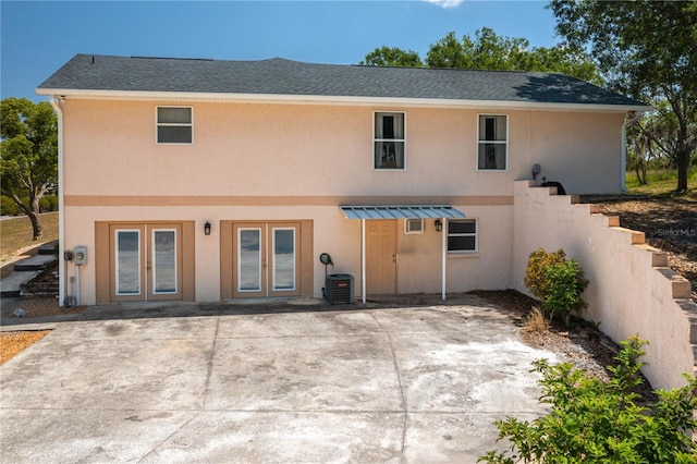 2390 Lake Easy Rd, Babson Park, FL 33827 - rear view of property featuring french doors, a patio area, central AC, a shingled roof, and stucco siding