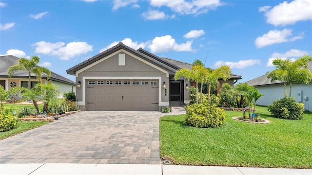 ranch-style house with a tile roof, a front yard, stucco siding, decorative driveway, and an attached garage
