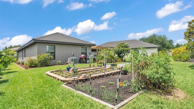 back of house featuring cooling unit, stucco siding, a vegetable garden, and a lawn
