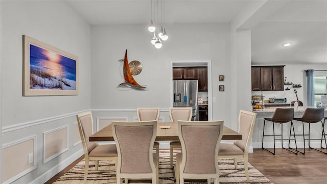 dining area featuring a decorative wall, a wainscoted wall, a toaster, recessed lighting, and wood finished floors