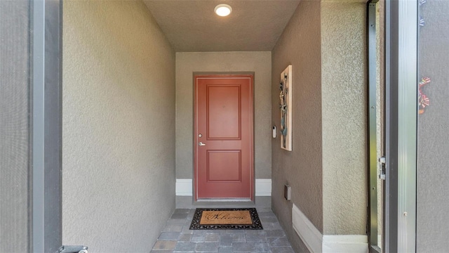 entrance to property featuring stucco siding