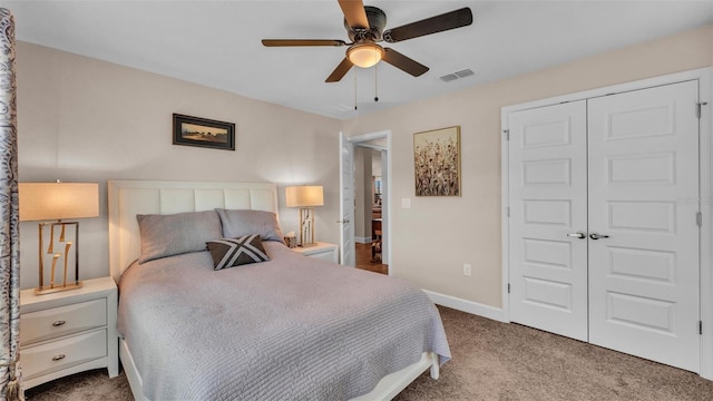 carpeted bedroom with a closet, visible vents, a ceiling fan, and baseboards