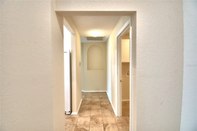 3430 Hilson Dr, Lakeland, FL 33812 - hallway featuring a textured wall, baseboards, and visible vents