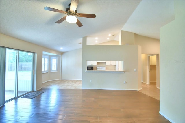 3430 Hilson Dr, Lakeland, FL 33812 - unfurnished living room featuring ceiling fan, vaulted ceiling, light wood-style floors, and baseboards
