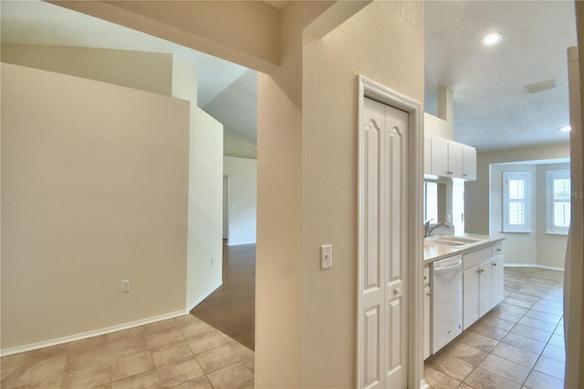3430 Hilson Dr, Lakeland, FL 33812 - kitchen featuring white cabinets, dishwasher, visible vents, a sink, and light tile patterned flooring