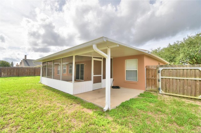 3430 Hilson Dr, Lakeland, FL 33812 - back of house with a gate, a fenced backyard, a patio area, a lawn, and a sunroom