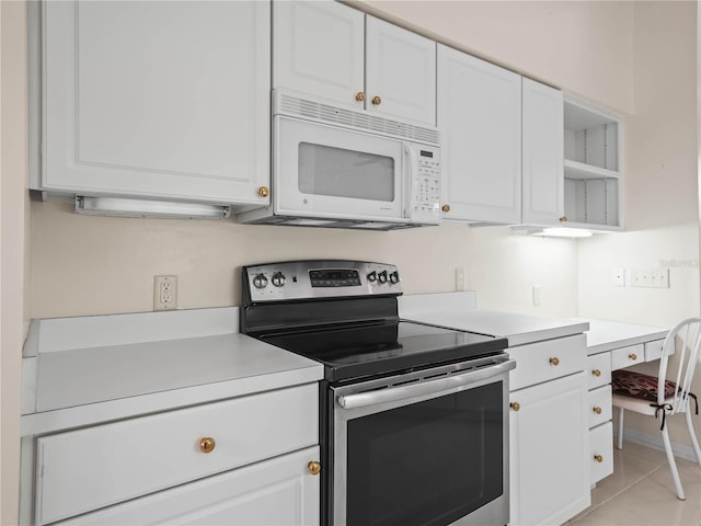 530 Greenway Dr, Lake Wales, FL 33898 - kitchen with electric stove, open shelves, white microwave, and white cabinets