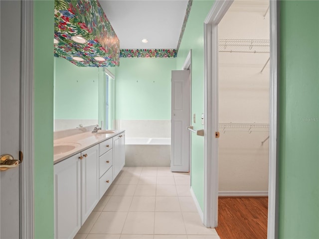 530 Greenway Dr, Lake Wales, FL 33898 - full bath featuring a sink, tile patterned flooring, double vanity, a spacious closet, and a garden tub
