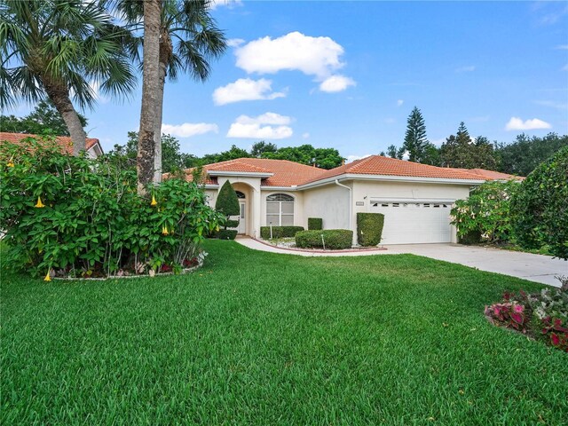 530 Greenway Dr, Lake Wales, FL 33898 - mediterranean / spanish home with a front yard, stucco siding, a tiled roof, an attached garage, and driveway