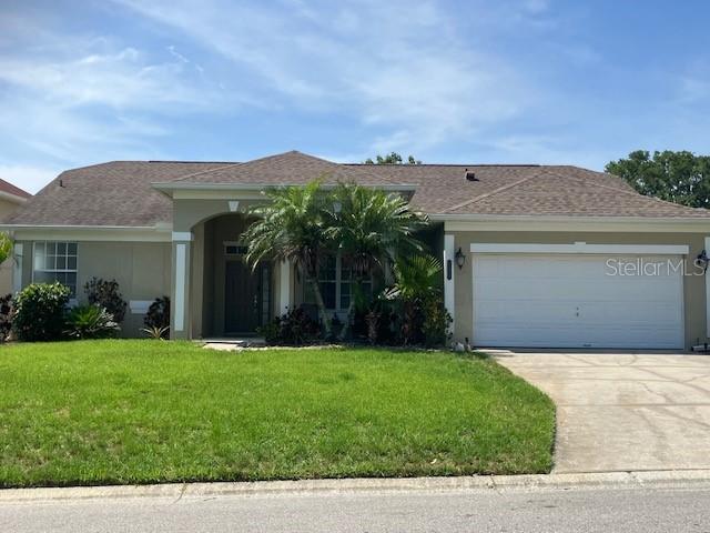 1681 Waterview Loop, Haines City, FL 33844 - ranch-style house with a front yard, an attached garage, stucco siding, and driveway