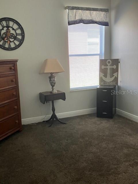 1681 Waterview Loop, Haines City, FL 33844 - living area featuring dark colored carpet and baseboards