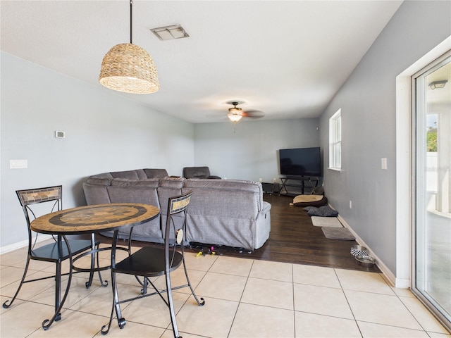 dining space featuring light tile patterned floors, visible vents, ceiling fan, and baseboards