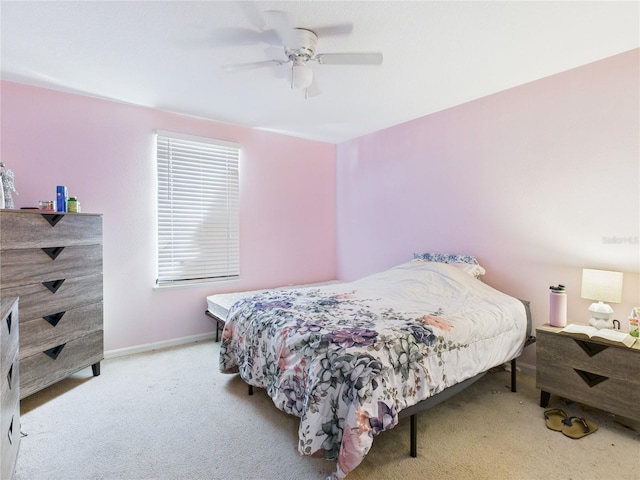 carpeted bedroom with a ceiling fan and baseboards