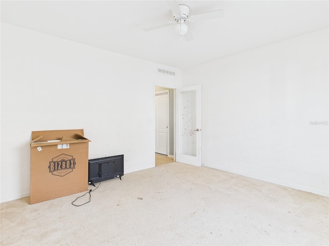 spare room featuring visible vents, ceiling fan, and carpet floors