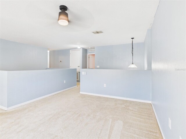 carpeted empty room with visible vents and baseboards
