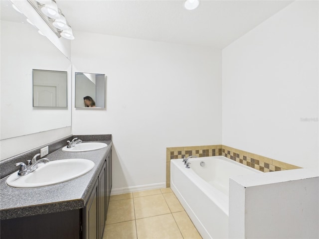 bathroom with a garden tub, double vanity, a sink, and tile patterned floors